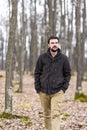 Handsome young man with hands in his pockets walking in the fore Royalty Free Stock Photo