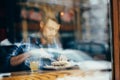 Handsome young man having lunch in elegant restaurant alone