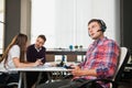 Handsome young man in headphones hold digital tablet at business office. Royalty Free Stock Photo