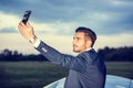 Handsome young man by his car with cell phone Royalty Free Stock Photo