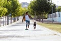 Handsome young man with his dog skateboarding in the park. Royalty Free Stock Photo