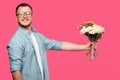 handsome young man holding bouquet of flowers and smiling at camera isolated