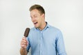 Handsome young man holding chololate ice-cream on isolated white background