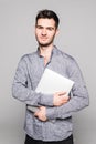 Confident handsome young man holding laptop and walking away isolated on white background Royalty Free Stock Photo