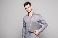 Confident handsome young man holding laptop and walking away isolated on white background Royalty Free Stock Photo