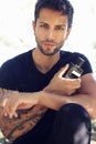 Handsome young man holding perfume