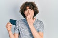 Handsome young man holding ssd memory covering mouth with hand, shocked and afraid for mistake Royalty Free Stock Photo