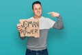 Handsome young man holding woman power banner pointing finger to one self smiling happy and proud