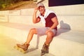 Handsome young man with inline roller skates sitting on stairs Royalty Free Stock Photo