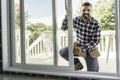 handsome young man installing bay window in a new house construction site Royalty Free Stock Photo