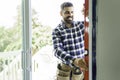 handsome young man installing bay window in a new house construction site with level Royalty Free Stock Photo