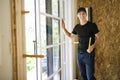 A handsome young man installing Double Sliding Patio Door in a new house construction site