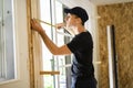 A handsome young man installing Double Sliding Patio Door in a new house construction site