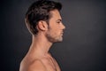 Handsome young bearded man isolated. Portrait of shirtless muscular man is standing on grey background. Men care concept Royalty Free Stock Photo