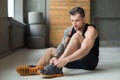 Handsome young man lace shoes at gym after training Royalty Free Stock Photo