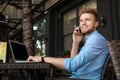 Handsome young man with laptop sitting at table in cafe Royalty Free Stock Photo