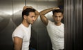 Handsome young man leaning against mirror inside an elevator (lift) Royalty Free Stock Photo