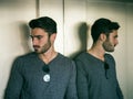 Young man leaning against mirror in elevator or lift Royalty Free Stock Photo