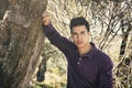 Handsome young man leaning against olive tree Royalty Free Stock Photo