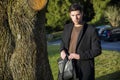 Handsome young man leaning against tree Royalty Free Stock Photo