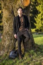 Handsome young man leaning against tree Royalty Free Stock Photo