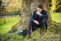 Handsome young man leaning against tree Royalty Free Stock Photo