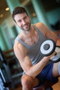 Handsome young man lifting weights in a fitness club Royalty Free Stock Photo