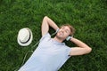 Handsome young man listening to music on green grass in park Royalty Free Stock Photo