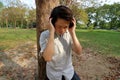 Handsome young man listening to music with headphones in the public outdoor park. Royalty Free Stock Photo