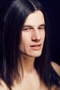 handsome young man with long hair naked torso on black backgroun