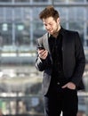 Handsome young man looking at mobile phone text message Royalty Free Stock Photo