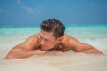 Handsome young man in the ocean at the tropical beach at island luxury resort Royalty Free Stock Photo