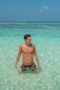 Handsome young man in the ocean at tropical beach in island luxury resort Royalty Free Stock Photo