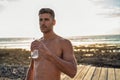 Handsome young man after outdoor workout drinking water. Athletic , muscular shirtless guy resting Royalty Free Stock Photo