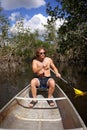 Handsome Young Man Paddling Canoe through Florida Everglades Backwaters Royalty Free Stock Photo