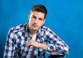 Handsome young man with plaid shirt on blue