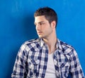 Handsome young man with plaid shirt on blue