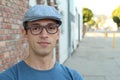 A handsome young man in plain clothes wearing hat and glasses Royalty Free Stock Photo
