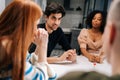 Handsome young man playing fun cards games telling associations to multiethnic friends, enjoying pastime activity Royalty Free Stock Photo