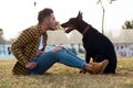 Handsome young man playing with his dog in the park. Royalty Free Stock Photo