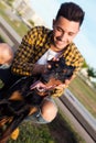 Handsome young man playing with his dog in the park. Royalty Free Stock Photo