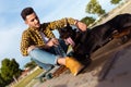 Handsome young man playing with his dog in the park. Royalty Free Stock Photo