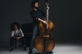 handsome young man playing violoncello while his partner sitting at piano blurred