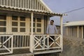 An handsome young man posing under the porch of a typical cottage house along the beach at Costa da Caparica, wearing sunglasses Royalty Free Stock Photo