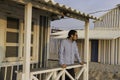 An handsome young man posing under the porch of a typical cottage house along the beach at Costa da Caparica, wearing sunglasses Royalty Free Stock Photo