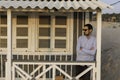 An handsome young man posing under the porch of a typical cottage house along the beach at Costa da Caparica, wearing sunglasses Royalty Free Stock Photo