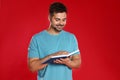 Handsome young man  book on red background Royalty Free Stock Photo