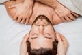 Man receiving head massage by two masseurs Royalty Free Stock Photo