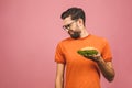 Handsome young man refusing unhealthy burger isolated over pink background. Diet concept. With copy space for text Royalty Free Stock Photo