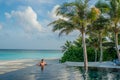 Handsome young man relaxing in the infinity swimming pool at the tropical island luxury resort Royalty Free Stock Photo